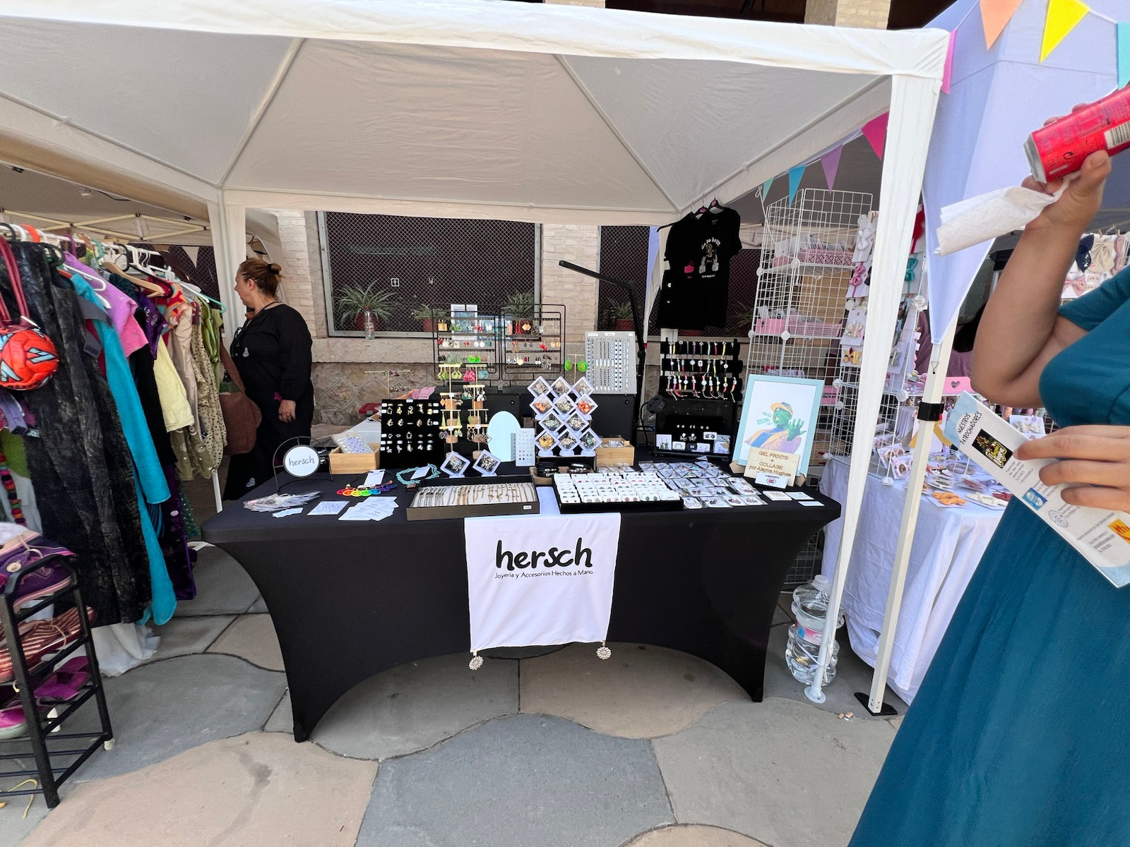 Hersch table beneath a white canopy at an open-air market